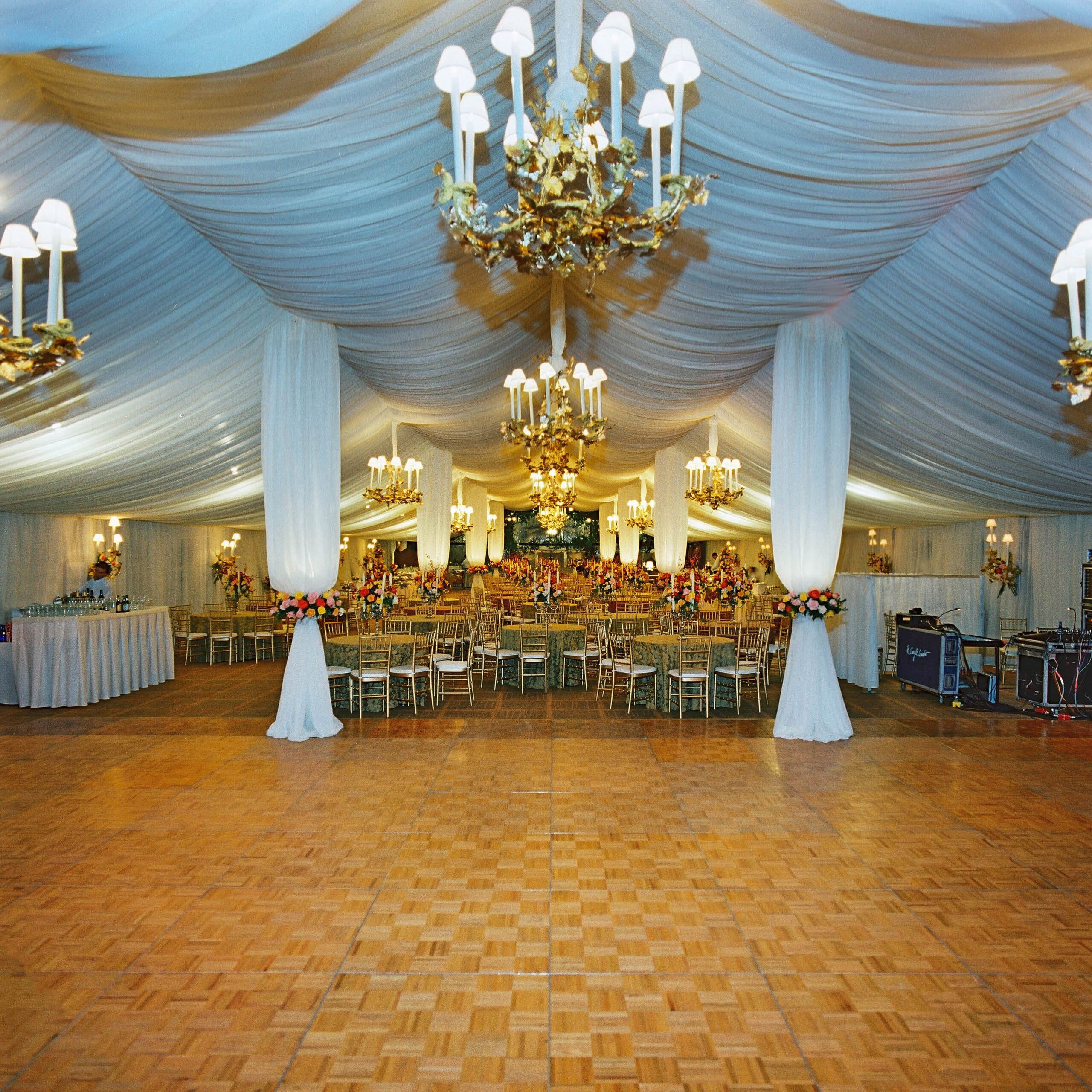 A large room set up and decorated for a wedding, with a large dance floor.