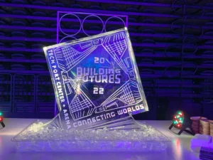 A crystal-clear ice sculpture engraved with 'Tech Port Center,' serving as a striking centerpiece for a corporate event.
